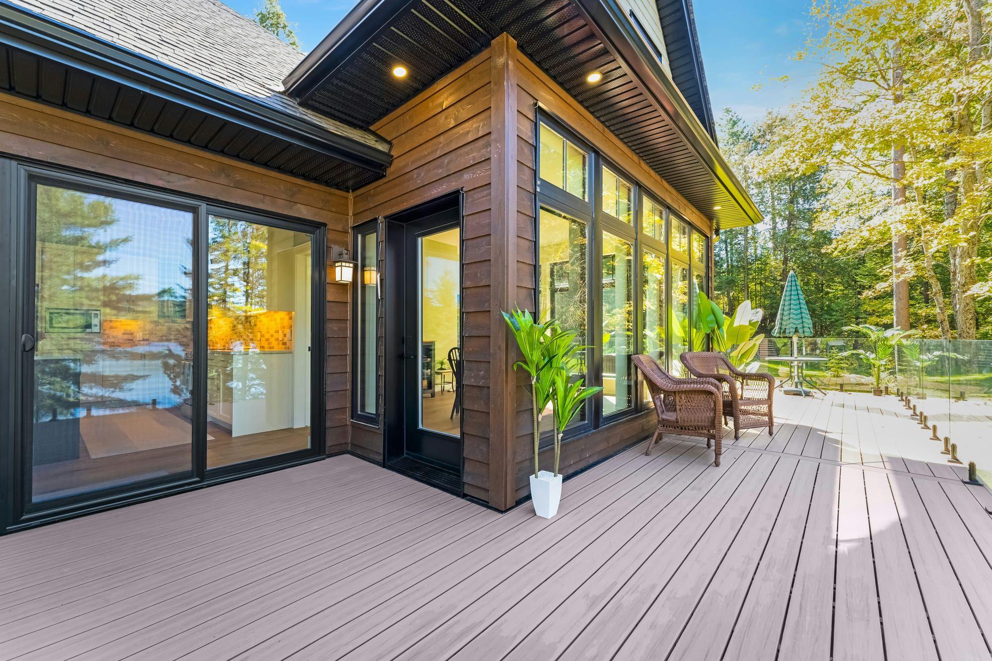 Composite deck with glass railing off the back of a modern home