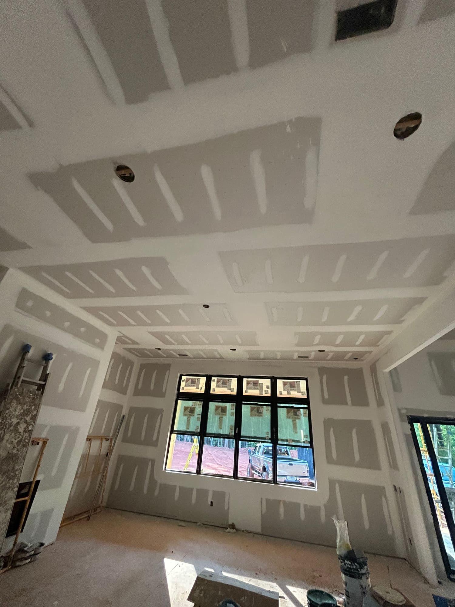 Taped and mudded drywall ceiling in new construction living room