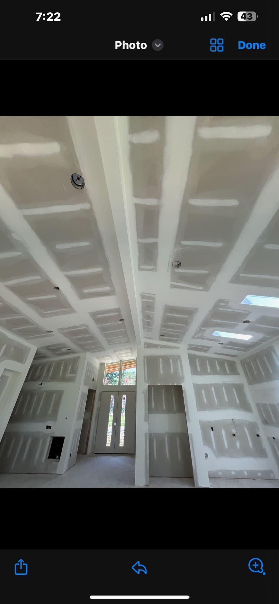Finished coffered drywall ceiling leading to entry doors