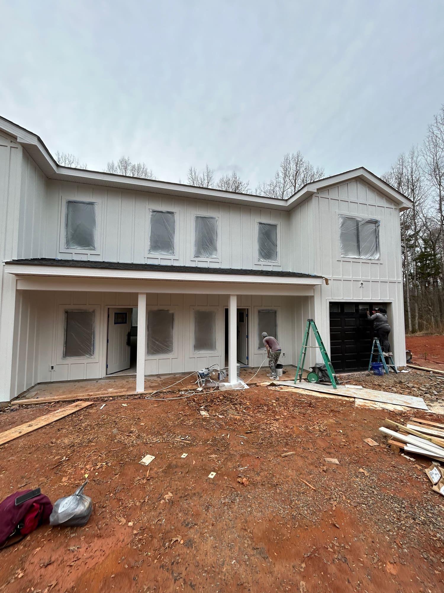 Modern farmhouse exterior repainted white with black trim and garage doors, Charlotte NC