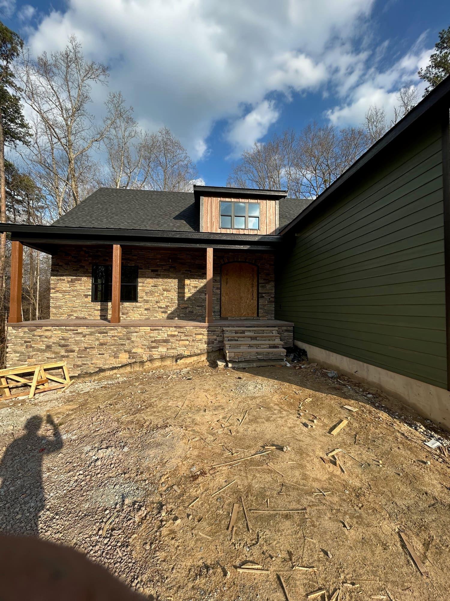 Stone and dark green exterior paint with covered porch, front entry