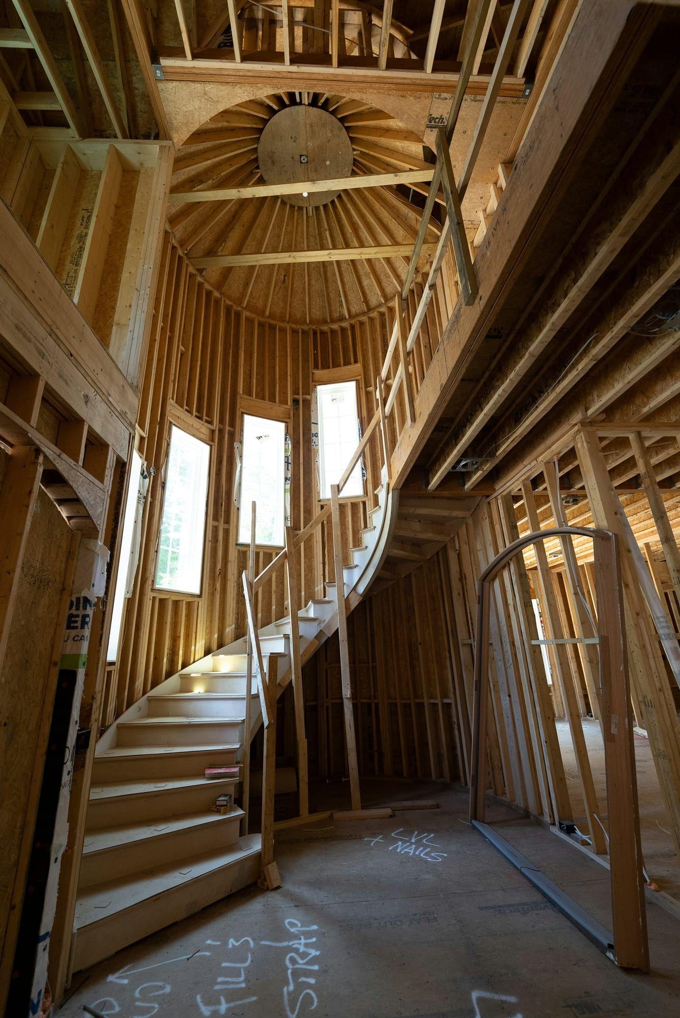 Tall vaulted framing with curved staircase during construction