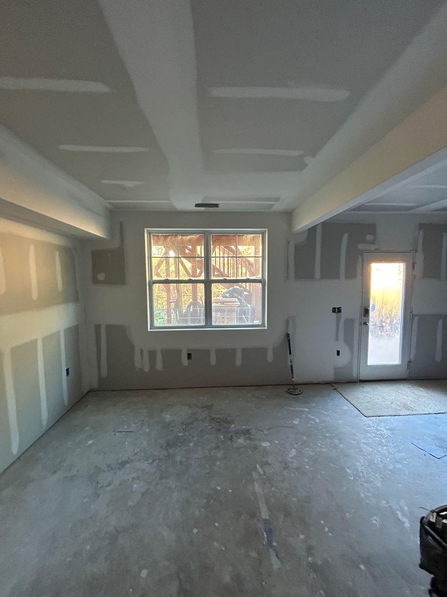 Garage conversion with drywall, window, and exterior door installed