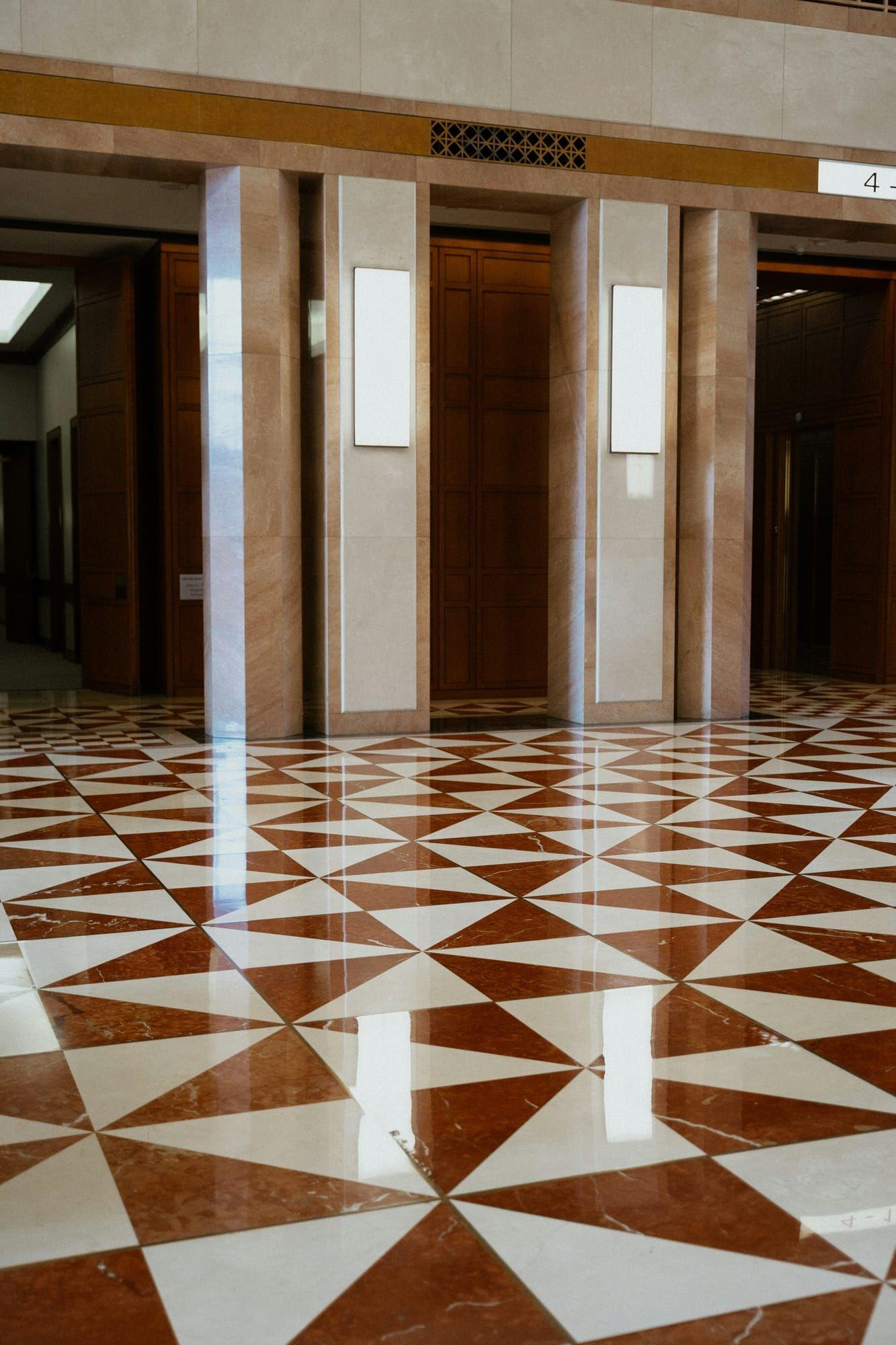 Glossy patterned marble tile floor in a building lobby